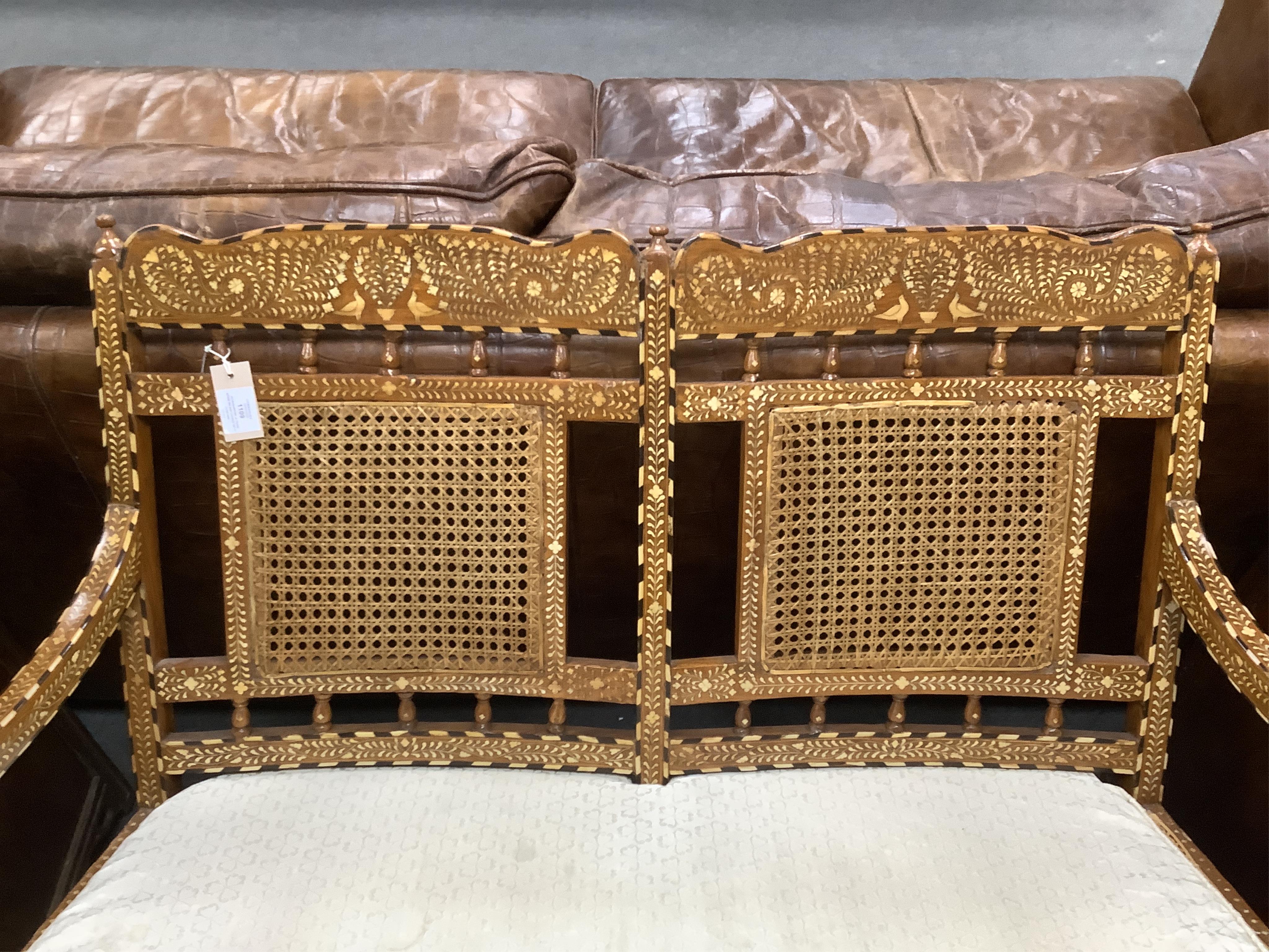 Hoshiarpur, a teak bone inlaid caned settee, width 107cm, depth 48cm, height 97cm. Condition - good